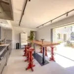 Cuisine équipée avec îlot central et vue sur terrasse au Mas du Moulin