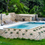 Piscine avec terrasse en pierres et transats dans une résidence de prestige en Drôme provençale