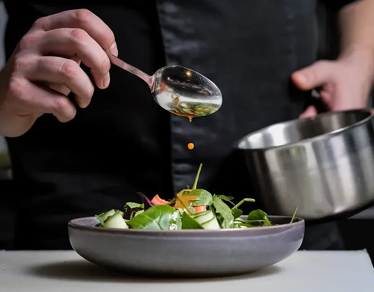 Alice, cheffe à domicile, finalise une assiette avec précision lors d’un service gastronomique