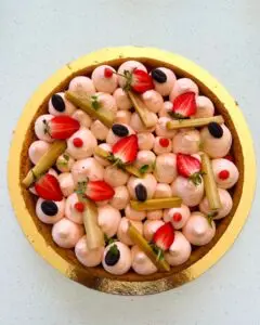 Tarte à la fraise et à la rhubarbe avec crème légère, fraises fraîches et bâtonnets de rhubarbe